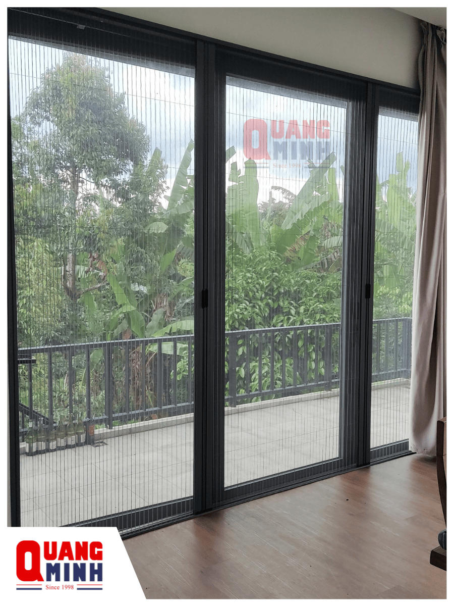 3 tấm cửa được lắp lưới chống muỗi, bên ngoài cửa là hành lang và cầu thang dẫn xuống tầng dưới, xung quanh nhà là cây xanh, bên trong phòng có rèm che bằng vải