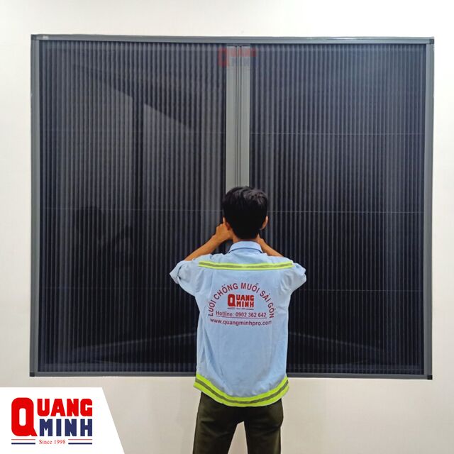 Người nhân viên kỹ thuật của Quang Minh đang kéo cửa lưới chống muỗi dạng kéo xếp