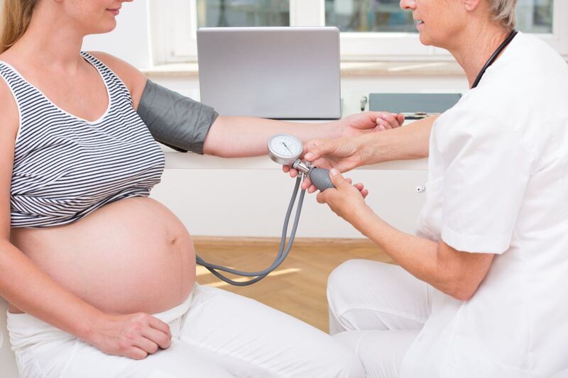 Bác sĩ đang đo huyết áp cho một phụ nữ mang thai. cách xác đinh chỉ số huyết áp cao