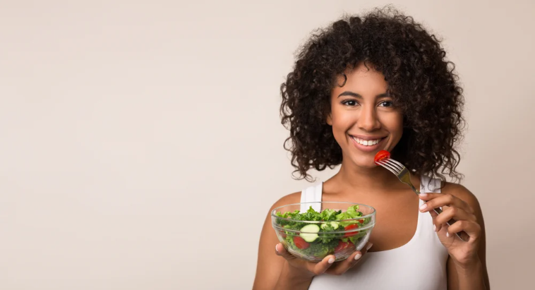 Cô gái đang cầm một bát salad